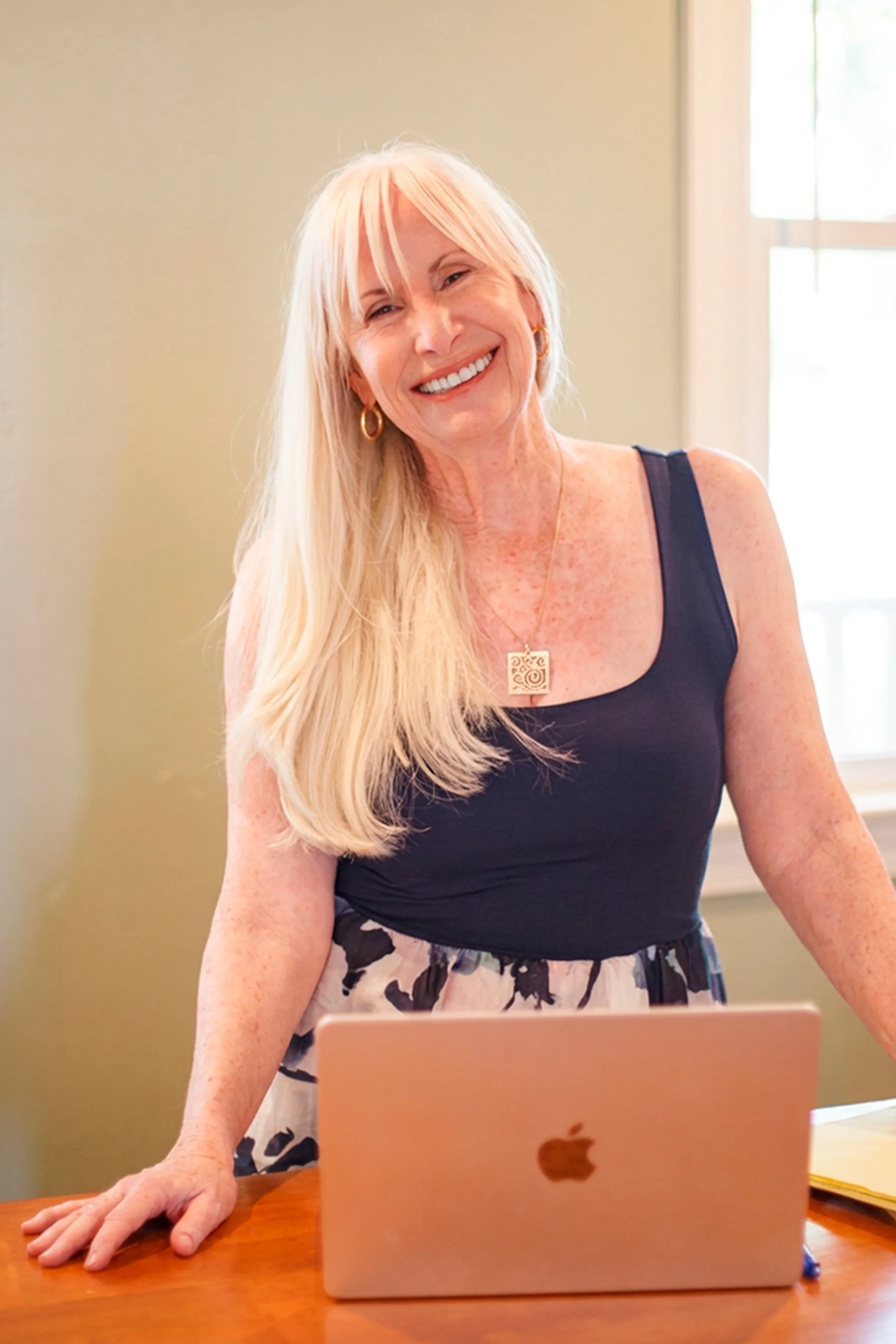 Janice Shayne standing at her desk, smiling