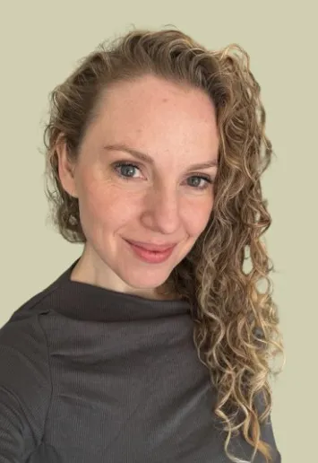 Tasha Shayne, smiling, with long curly hair